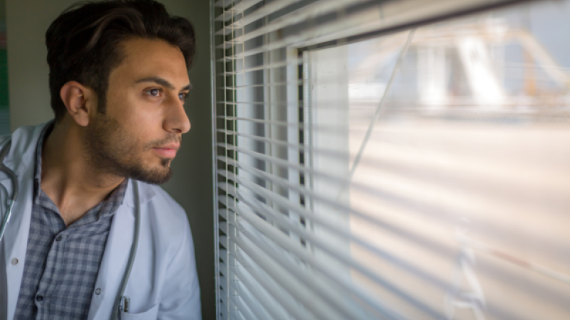 médico-joven-mira-ventana