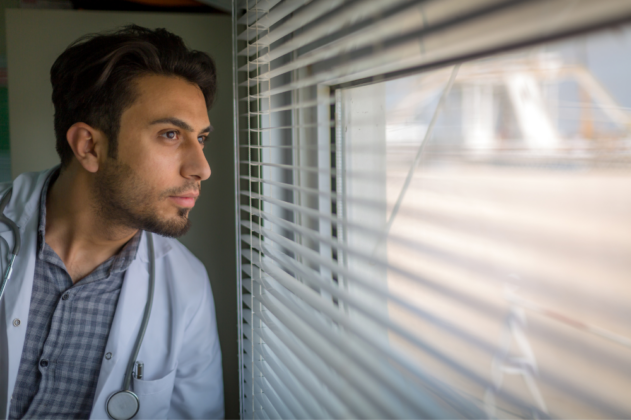 médico-joven-mira-ventana